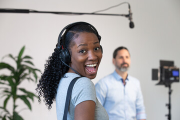 African American Woman Happy Wearing Headphones Working as an Audio Person on a Video Production...