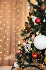 The Christmas tree is decorated with different toys. Against the background of bokeh garlands.