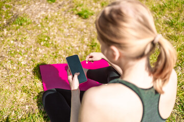 Woman does sport activities programes fit watch synchronizing data with mobile phone wirelessly...