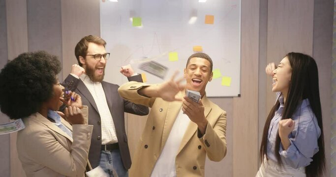 Latin man throws money sharing joy with colleagues in office