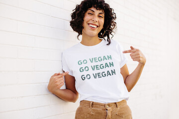 Happy vegan activist wearing a GO VEGAN shirt - obrazy, fototapety, plakaty
