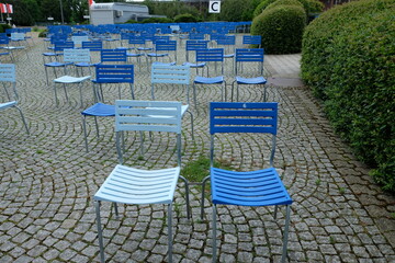 FU 2021-08-01 Rheinpark 65 Auf den Pflastersteinen stehen blaue Stühle