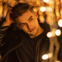 Stylish night city portrait of a handsome guy walking on the street