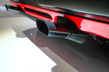 Chrome-plated exhaust pipe close-up of the red sportscar car close-up. Car repair. Car details 