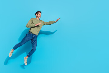 Fototapeta na wymiar Full body photo of funny millennial brunet guy run wear shirt jeans sneakers isolated on blue background