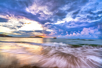Beautiful sunrise on the beach waves lapping at the shore of the soft great to welcome the new day