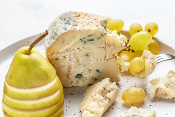 Danish blue cheese. Tasty blue cheese on a wooden background and burlap. Dorblu cheese pieces. Food recipe background. Close up