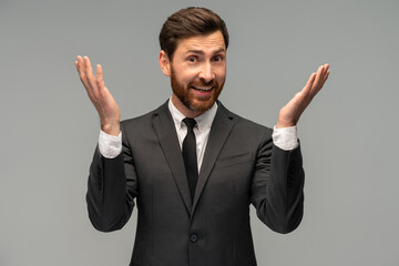 Waist up portrait view of the modern business man in formal suit raised arms and laughing isolated on grey background