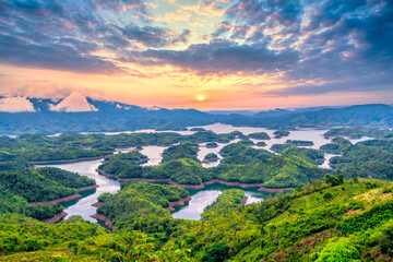 Ta Dung Lake seen from above with a peaceful sunrise sky background. This is a large hydroelectric lake in the Central Highlands of Vietnam