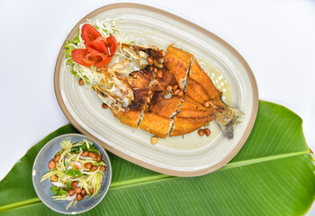 Deep-fried Seabass with Fish Sauce - Thai food, top view on white background.