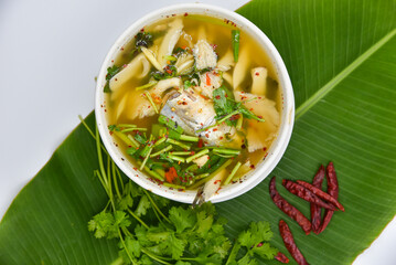 Red Tail Catfish In Clear Tomyum Soup - Thai food, top view on white background.
