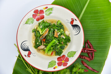 Stir-fried Baby Cabbage with Salted Fish - Thai food, top view on white background.
