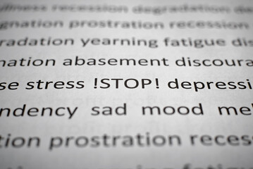 Obraz premium Mental health, stop depression, psychological problems concept. Printed text stress, depression, sad mood, prostration, abasement on white paper close-up. Selective focus on word Stop, low angle view