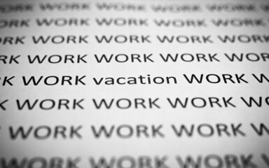 Lots of work and little rest concept. Printed text Work and Vacation on white paper, close-up. Selective focus on word vacation, low angle view, macro photo