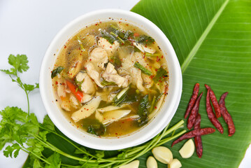 Red Tail Catfish In Clear Tomyum Soup - Thai food, top view on white background.