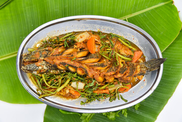 Steamed Whole Fish in Sauce - Thai food, top view on white background.