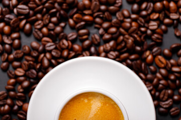 Hot fresh black coffee with milk foam for morning menu in white ceramic cup with coffee beans roasted on.