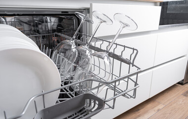 Open dishwasher with clean dishes in the kitchen