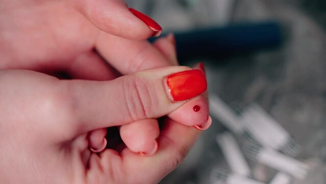 The woman has diabetes and analyzes her blood sugar. Woman squeezes red blood from finger shob to test. The pancreas does not produce insulin in human body, so you need to control blood glucose levels