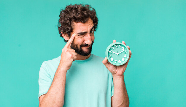 young adult hispanic crazy man with an alarm clock