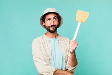 young adult hispanic crazy man with a fly swatter
