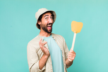 young adult hispanic crazy man with a fly swatter