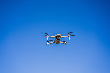 Quadcopter drone with the camera against the blue sky