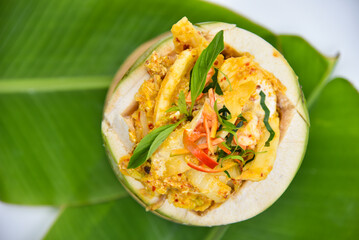 Steamed Curry Seafood in Young Coconut - Thai food, top view on white background.