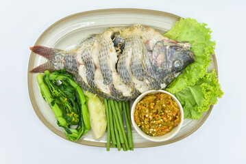 Steamed Nile Tilapia Fish and Fermented Fish Spicy Dip - Thai food, top view on white background.