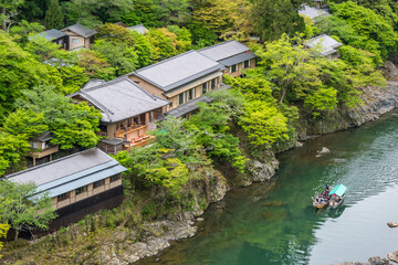 Fototapeta na wymiar Traditional japanese style wooden houses in the mountains with river access and boat
