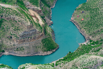 Obraz premium mountain landscape, a deep canyon with a blue river at the bottom, a camp site and a road under construction