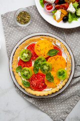 Overhead view of sliced heirloom tomato ricotta quiche on plate