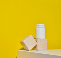 white plastic jar for pills, cream and medicines on a yellow background. Container for substances