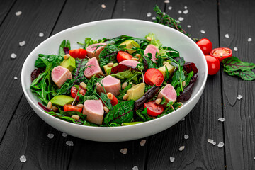 Japanese traditional salad with pieces of medium-rare grilled Ahi tuna and sesame with fresh vegetable on a bowl.