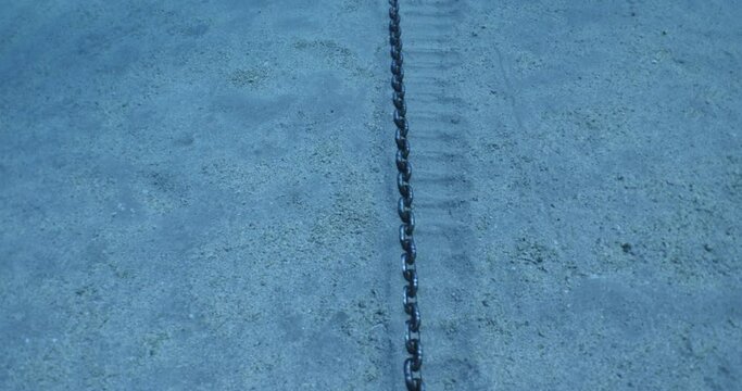 anchor chain at the bottom of sea on sand moving ocean scenery underwater