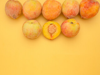 Pile of fresh peaches fruit over a yellow background