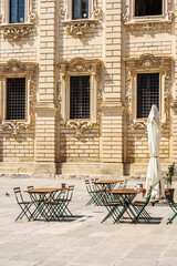 Fototapeta na wymiar Empty tables of a closed coffee shop in the main baroque square of Lecce, Apulia Italy