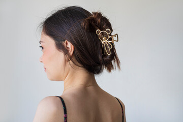 Fototapeta premium Young woman with beautiful hair clips on grey background