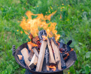 preparing a fire with wood and charcoal on a small cast iron grill