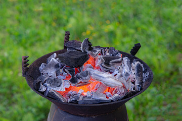 preparing a fire with wood and charcoal on a small cast iron grill