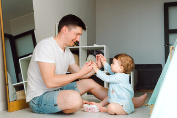 Brunette father spent time playing with daughter taking hands together and look each other