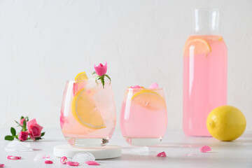 Pink rose cocktails, drinks or lemonade with rose flowers and lemon on white background. Close up....