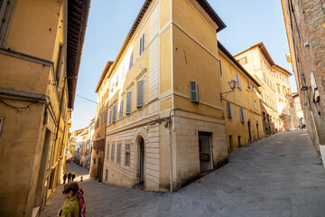 View on narrow and cozy street in the old town of Siena city in Italy. Concept of ancient...