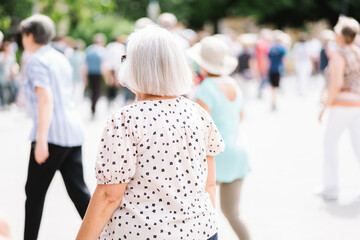 Fototapeta premium unrecognizable senior woman dancing in an outdoor square