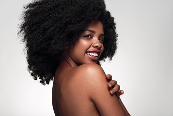 Cheerful black woman touching bare shoulder