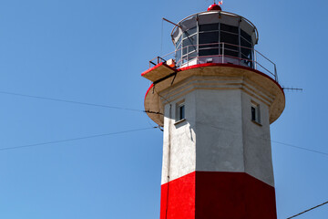 Lighthouse on the sea. Red-white lighthouse on the island. Lighthouse against the sky. Beautiful building by the sea. Ukrainian lighthouse.