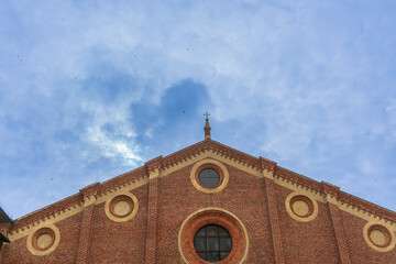 Swallows fly in the cloudy sky over the Basilica of Santa Maria delle Grazie in Milan on a cloudy...