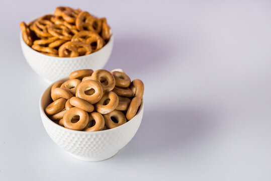 Small sushki and prezel on White Bowl Blue background Sweet wheat dough Horizontal Copy space