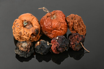 Rotten apple on black acrylic background.