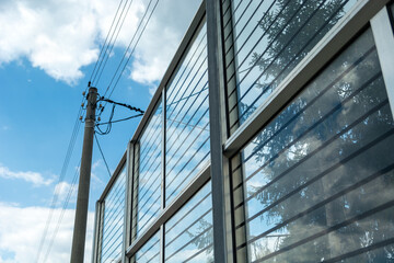 Obraz premium Electric pole standing by glass noise barriers